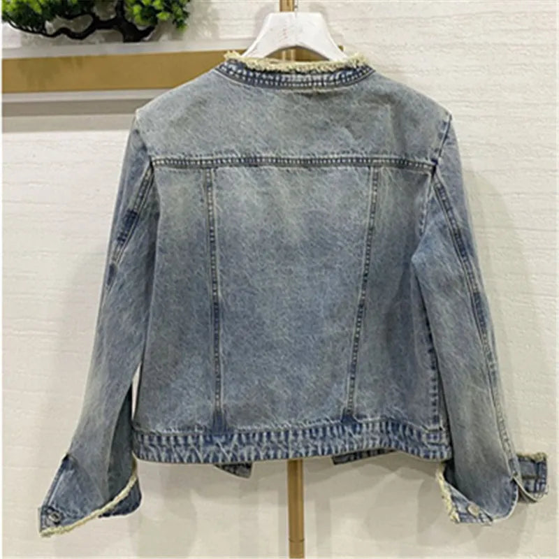 cette veste en jean pour femme présente de lourdes perles inspirées de l'industrie et un design à col rond. C'est une option de vêtement d'extérieur à la mode et courte.